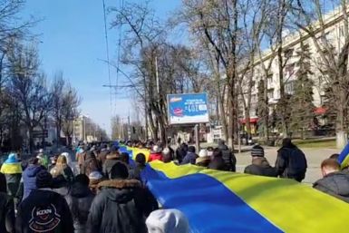 Rekaman siaran langsung menunjukkan orang-orang membawa spanduk berwarna bendera Ukraina saat mereka memprotes di tengah invasi Rusia ke Ukraina, di Kherson, Ukraina, 13 Maret 2022 dalam gambar diam ini dari video media sosial yang diperoleh REUTERS