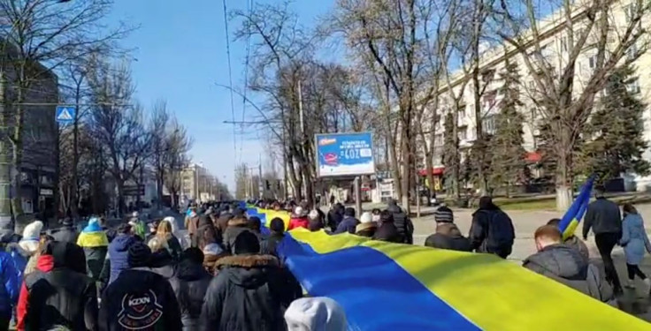 Rekaman siaran langsung menunjukkan orang-orang membawa spanduk berwarna bendera Ukraina saat mereka memprotes di tengah invasi Rusia ke Ukraina, di Kherson, Ukraina, 13 Maret 2022 dalam gambar diam ini dari video media sosial yang diperoleh REUTERS