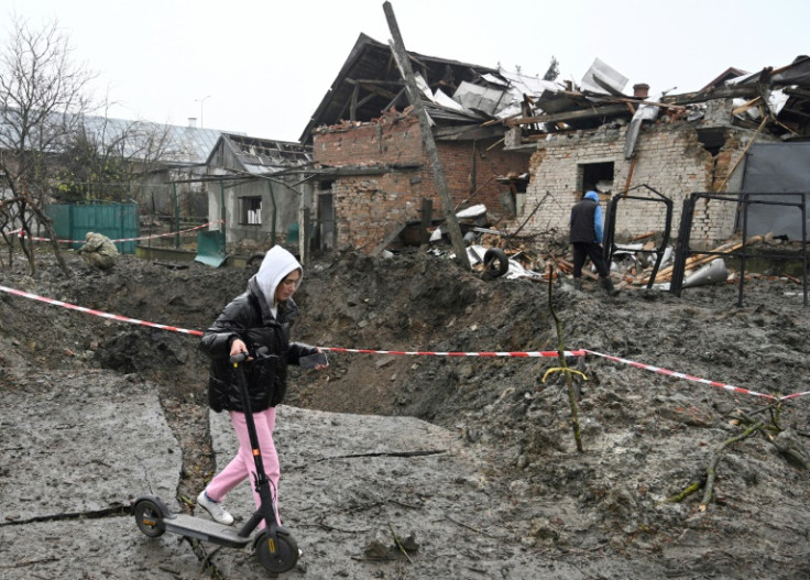 Seorang gadis berjalan dengan skuternya melewati kawah setelah serangan rudal Rusia di sebuah desa dekat kota Lviv, Ukraina barat