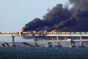Asap hitam mengepul dari kebakaran di jembatan Kerch yang menghubungkan Krimea ke Rusia, setelah sebuah truk meledak, di dekat Kerch, pada 8 Oktober 2022.