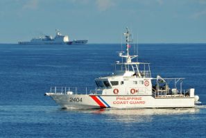 Kapal penjaga pantai Filipina (kanan) berlayar melewati kapal penjaga pantai Tiongkok di dekat Beting Scarborough di Laut Cina Selatan pada tahun 2019