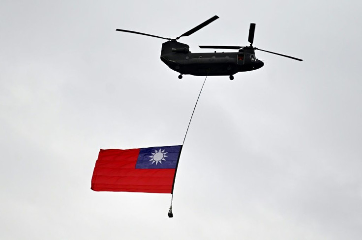 Sebuah helikopter militer mengibarkan bendera Taiwan selama parade hari nasional di Taipei pada 10 Oktober. Beijing menganggap Taiwan sebagai wilayahnya sendiri dan berjanji suatu hari akan merebut pulau yang memiliki pemerintahan sendiri itu.