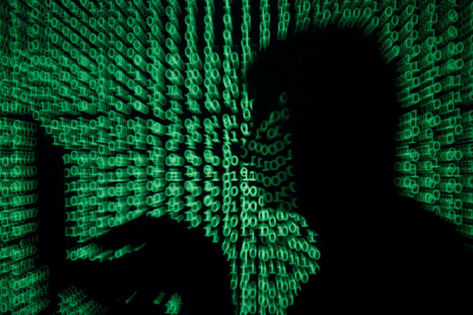 Seorang pria memegang komputer laptop saat kode dunia maya diproyeksikan padanya dalam gambar ilustrasi ini