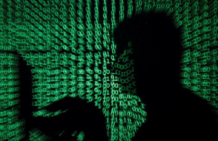 Seorang pria memegang komputer laptop saat kode dunia maya diproyeksikan padanya dalam gambar ilustrasi ini