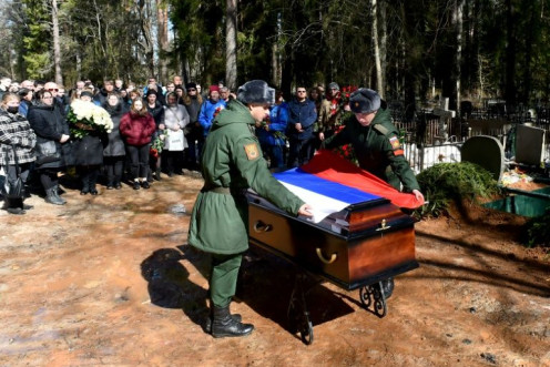 Tentara menutupi peti mati Avrov dengan bendera nasional -- jumlah kematian Rusia yang pasti tidak diketahui, dengan penghitungan resmi terbaru 1.351 diberikan pada 25 Maret