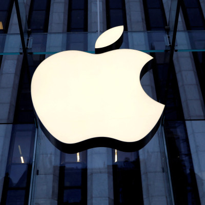 Logo Apple Inc. terlihat tergantung di pintu masuk toko Apple di 5th Avenue di New York