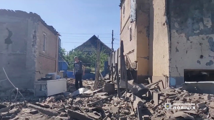 Seorang pria berjalan di antara puing-puing di dekat bangunan yang rusak, saat invasi Rusia ke Ukraina berlanjut, di Bakhmut