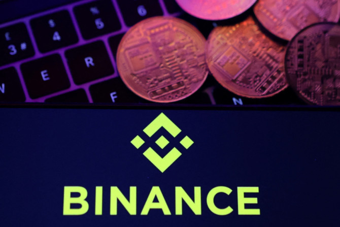Ilustrasi menunjukkan logo Binance dan representasi mata uang kripto