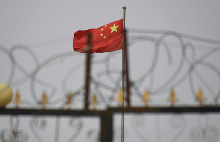 Bendera China di balik kawat berduri di kompleks perumahan di Yangisar di wilayah Xinjiang barat China pada Juni 2019