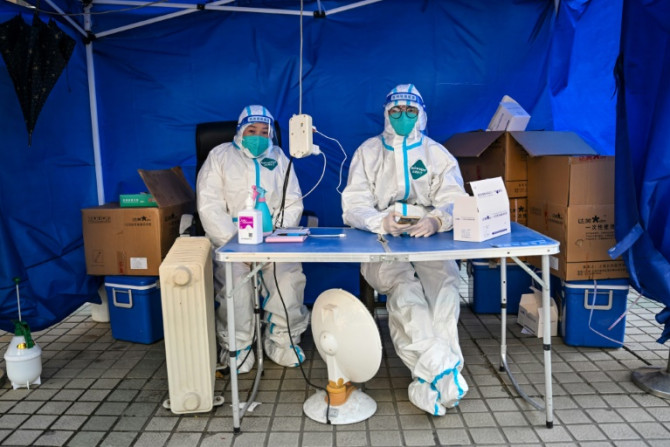 Petugas kesehatan menunggu orang memindai kode kesehatan untuk menguji virus corona Covid-19 di distrik Jing&#39;an di Shanghai pada 22 Desember 2022.