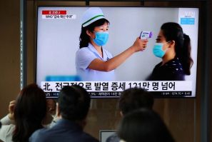 Orang-orang menonton TV yang menyiarkan laporan berita tentang wabah penyakit virus corona (COVID-19) di Korea Utara, di stasiun kereta api di Seoul, Korea Selatan, 17 Mei 2022.