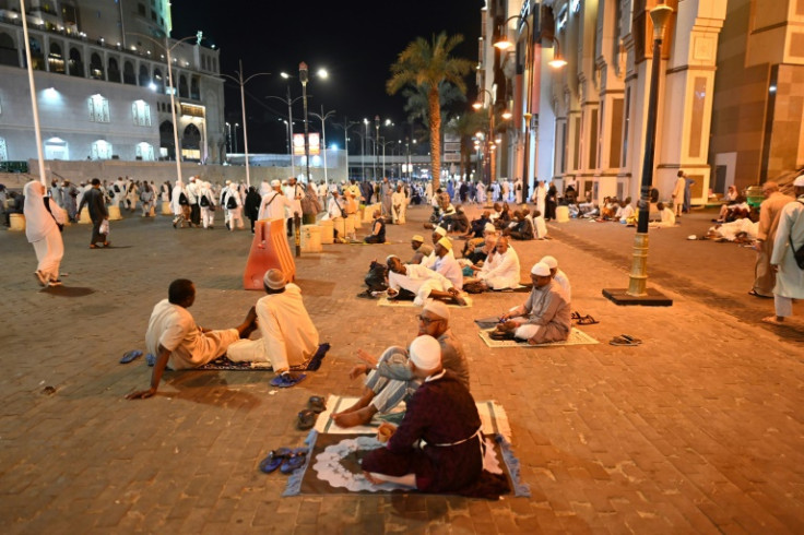Peziarah beristirahat di jalan setelah pengerahan tenaga mereka di tengah panasnya Arab Saudi