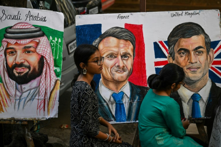Siswa memberikan sentuhan akhir pada lukisan Putra Mahkota Arab Saudi Mohammed bin Salman, Presiden Prancis Emmanuel Macron dan Perdana Menteri Inggris Rishi Sunak (dari kiri), menjelang KTT G20