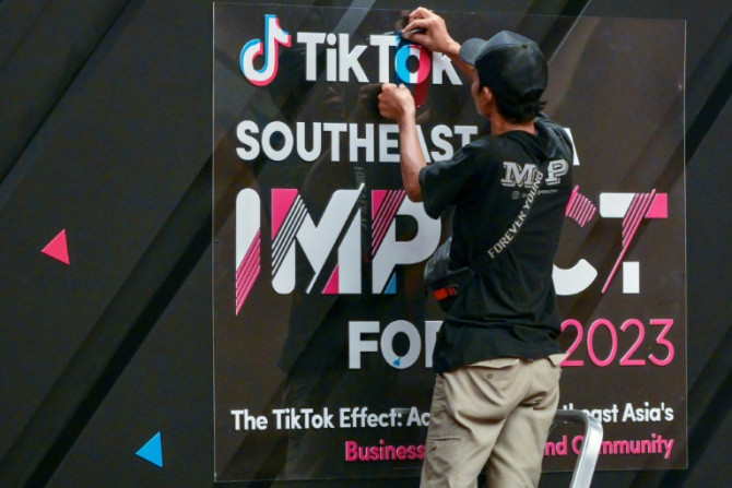 Seorang pekerja menyelesaikan papan tanda di depan TikTok Southeast Asia Impact Forum 2023 di Jakarta pada 15 Juni 2023.