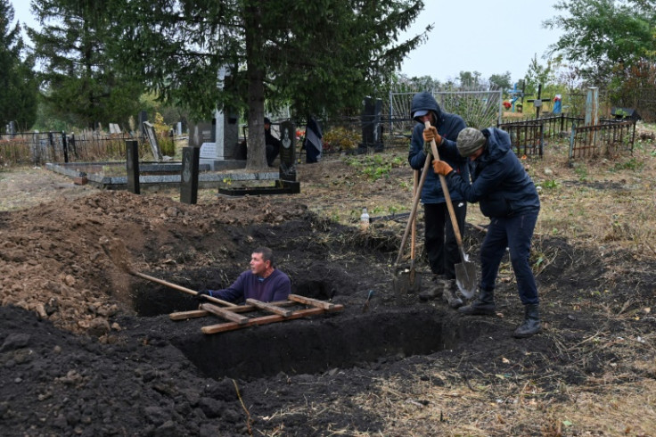 Penduduk setempat menggali kuburan di pemakaman di desa Hroza dua hari setelah serangan Rusia menewaskan lebih dari 50 orang
