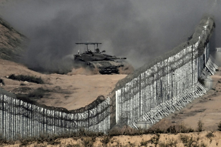 Dalam gambar yang diambil dari pagar perbatasan sisi Israel, sebuah tank Israel meluncur di dalam Jalur Gaza pada tanggal 5 November 2023 di tengah pertempuran yang sedang berlangsung antara Israel dan gerakan Hamas Palestina